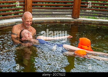 Haki-Flow, an innovative treatment method that relieves tension in the neck and shoulder area. Therapist Antonio pulls editor Angela Berg through the water in snake-like movements. Bagno Vignoni, Val d'Orcia, Italy Stock Photo