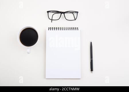 White notepad with black pen and glasses on light table,  Stock Photo