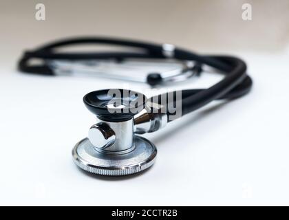 Black Stethoscope or phonendoscope on the white background close up. Selective focus, Treatment of cold or flu concept.  Stock Photo