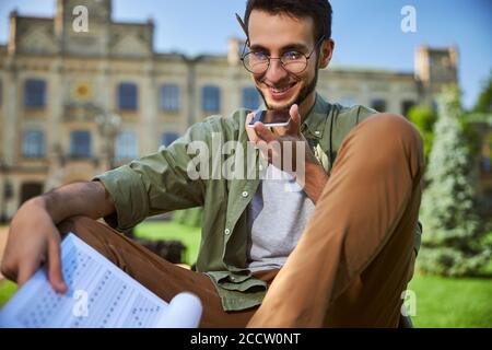 Joyful young man using his gadget outdoors Stock Photo