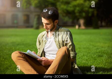 Focused young man writing with a pencil Stock Photo
