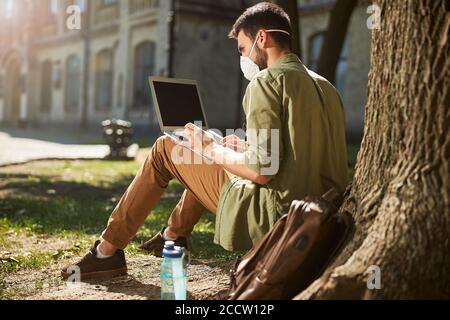 Concentrated male student working on his laptop Stock Photo
