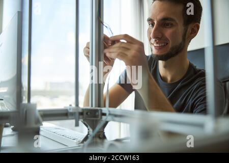 Cheerful young engineer checking the lab equipment Stock Photo