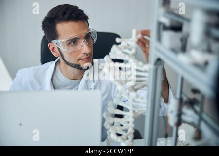 Medical student examining the 3D printed DNA model Stock Photo