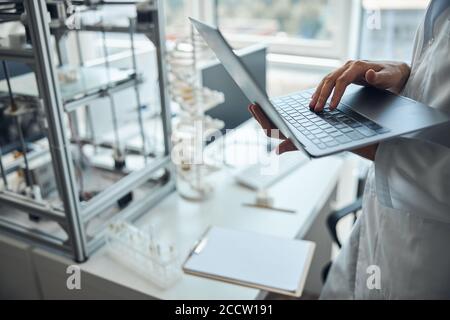 Man in a lab coat typing on the laptop Stock Photo