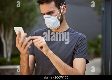 Focused man staring at his gadget outdoors Stock Photo