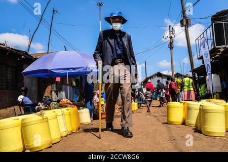 Nairobi, Kenya. 06th Aug, 2020. An elderly man wearing a facemask is seen walking past the busy streets surrounded by empty water Jerrycans. Credit: SOPA Images Limited/Alamy Live News Stock Photo