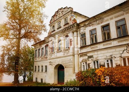 Beautiful old house and autumn yellow trees, antique building Stock Photo