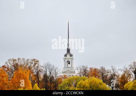 Ancient christian church and autumn yellow trees. Beautiful domes, high bell tower against the sky Stock Photo