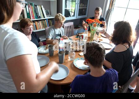 Polish family of three generations gathered around the table enjoying a home cooked pizza dinner together. Zawady Gmina Rzeczyca Poland Stock Photo