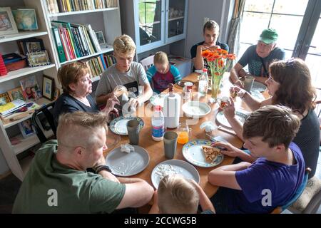 Polish family of three generations gathered around the dinner table enjoying home cooked pizza together. Zawady Gmina Rzeczyca Poland Stock Photo