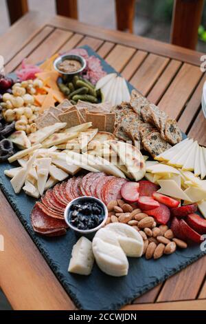 Charcuterie Board with fruit, vegetables, crackers, cheese, and dips. Stock Photo
