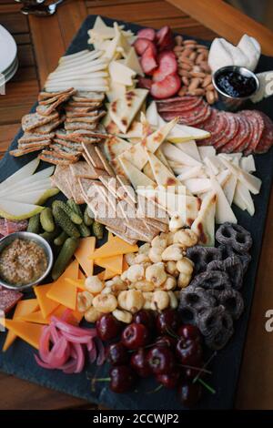 Charcuterie Board with fruit, vegetables, crackers, cheese, and dips. Stock Photo