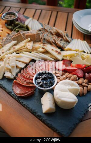 Charcuterie Board with fruit, vegetables, crackers, cheese, and dips. Stock Photo