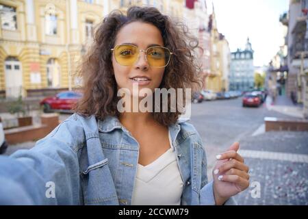 Young hispanic woman recording vlog by mobile phone outdoors. Stock Photo