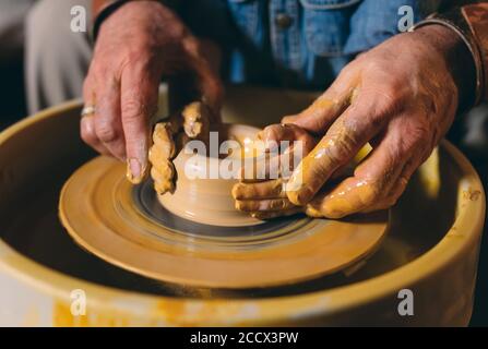 Pottery workshop. Grandpa teaches granddaughter pottery. Clay modeling Stock Photo