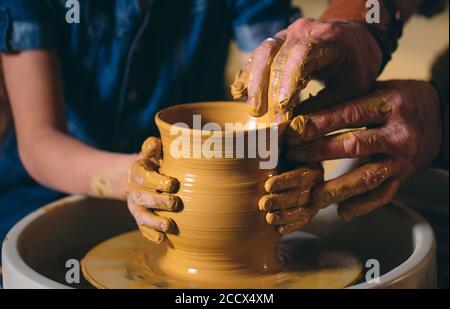 Pottery workshop. Grandpa teaches granddaughter pottery. Clay modeling Stock Photo