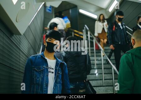 Man wear protective face mask in subway station with other people to protect virus. Covid-19 protection concept when go outside at public place Stock Photo