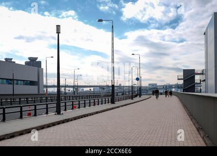 Quiet city with unidentified people riding bicycle and walking on pedestrian walkway and bicycle path Stock Photo