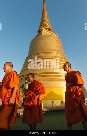 Monks walking past stupa at Wat Saket, Bangkok Stock Photo