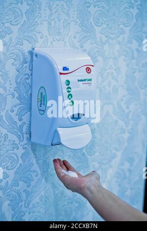 using hand sanitizer wall machine Stock Photo