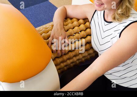 smiling woman making massage for back. Roll Massage machine is a way to  shape the figure. Skin Care, body care concept modern relax massage  equipment Stock Photo - Alamy