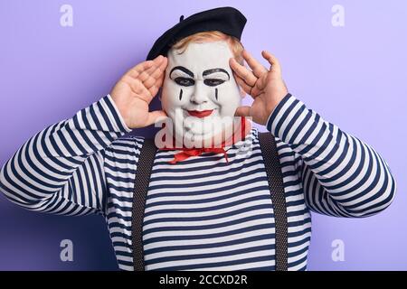 playful funny plump man touching his face with fingers looking at the camera. positive emotion and feeling Stock Photo