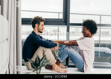 Romantic mixed race affectionate young newlyweds relax at modern hotel interior while vising foreign country in vacation Stock Photo