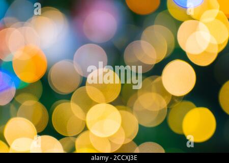 Shimmering abstract colored circles defocused christmas lights background. Blurred fairy lights. Out of focus holiday background christmas tree. Light bokeh from Xmas tree. Xmas and New Year theme. Stock Photo