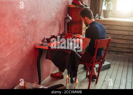 calm man working with a draft at workshop with modern interior. back view photo Stock Photo