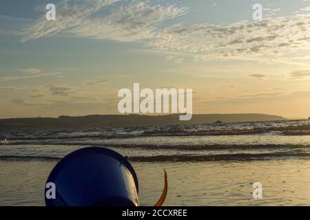 Children's sand bucket lying in the sand on the beach Stock Photo