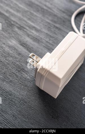 Travel power adapter with US power plug on a wooden background. Electrical concept Stock Photo