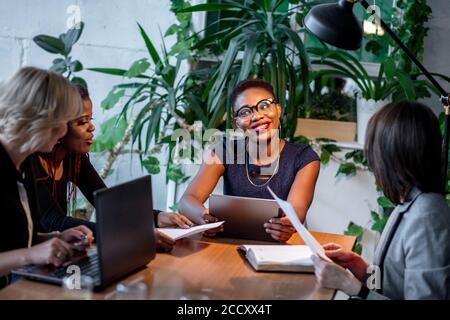 Real estate african female agent consulting young women about buying house or rent purchase mortgage, financial advisor shows investment contract at m Stock Photo