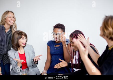 Female Conference members, having leaving party clinking their glasses with cocktails being happy to meet each other. Friendly company of adult women Stock Photo