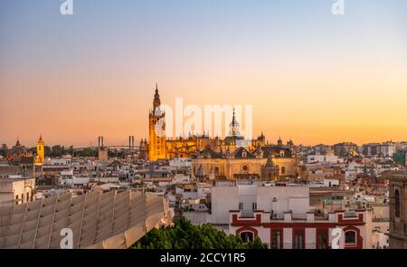 View from Metropol Parasol over the city at sunset, illuminated Cathedral of Seville with tower La Giralda, Seville, Andalusia, Spain Stock Photo