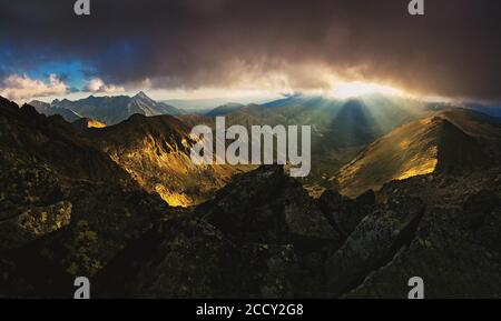 The rays of the setting sun that break through the peaks and clouds, Tatra National Park, Poland Stock Photo