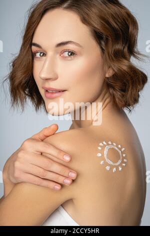 Woman with her hand on the shoulder looking ahead Stock Photo