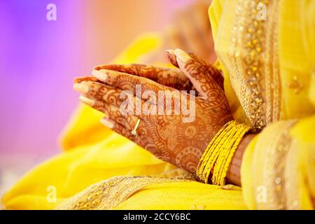 Hindu Bride crossing hands painted with henna for prayer on wedding eve, India Stock Photo