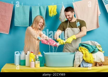 happy awesome couple having fun with wet clothes. positive atmosphere in laundry room. feeling and emotion Stock Photo