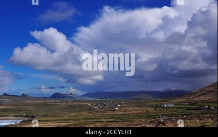 View over the scattered cottages on the coastal plain from Clogher head towards the Three Sisters and the snow capped Brandon Mountain with a spectacu Stock Photo