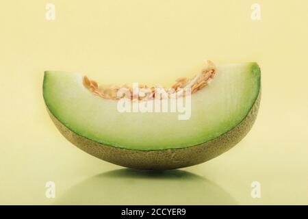 One slice of melon on the surface of the yellow base Stock Photo