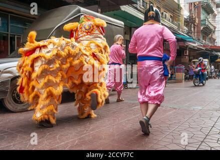 A Chinese dragon in the streets of chinatown in Bangkok, Thailand, performs the lion dance Stock Photo