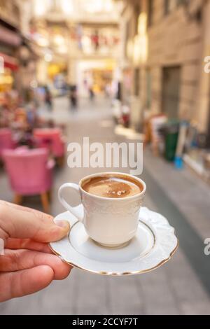 Mens hand holding cup of the traditional Turkish coffee close-up in Istanbul Stock Photo