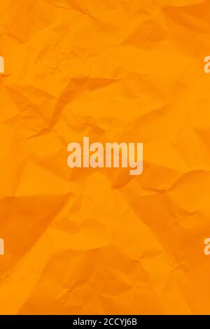 Textured crumpled orange paper background. Vertical Stock Photo