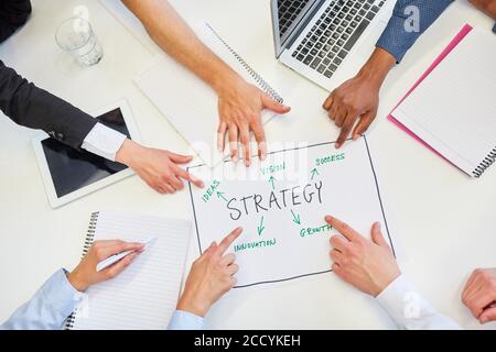 Business people pointing with hands at the strategy plan in a business meeting Stock Photo