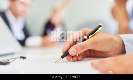 Hand of business man making notes with a pen in a meeting Stock Photo