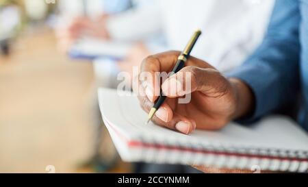 Hand of businessman using pen while writing a checklist in the office Stock Photo