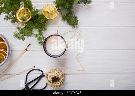 Hand made christmas wreath decorated with dry oranges on white table Stock Photo