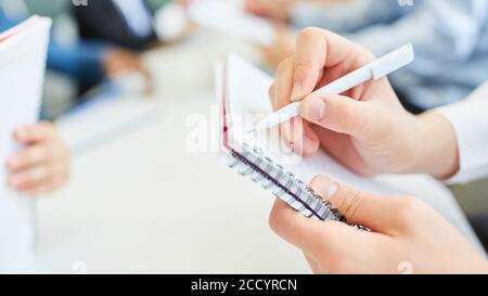 Hand of business woman making notes with a pen in a meeting in the office Stock Photo