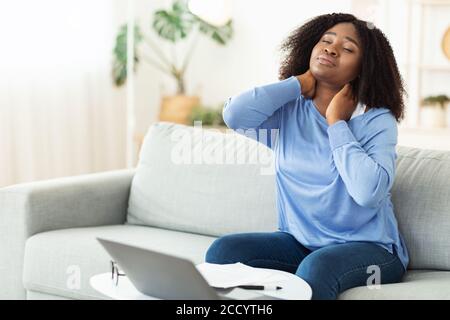 Businesswoman with neck pain after long hours at work Stock Photo